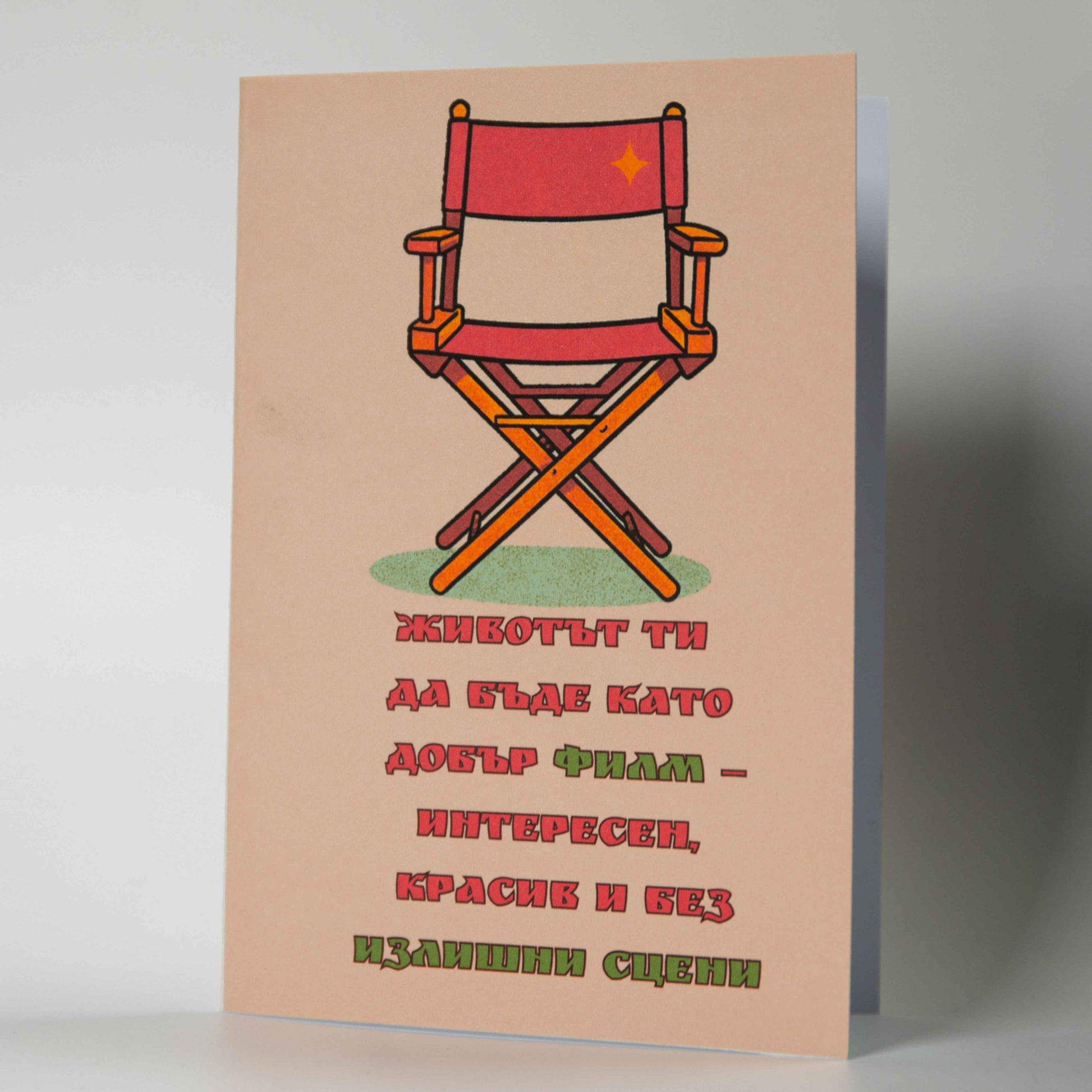 Снимка 1 (Лице): Картичка за рожден ден с червен режисьорски стол и текст за живот като на кино - Картичарница Снимка 2 (Комплект): Оригинална картичка за киноман с плик и послание без излишни сцени